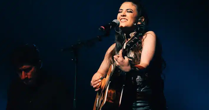Karla Breu Karla Breu cantando y tocando la guitarra en concierto